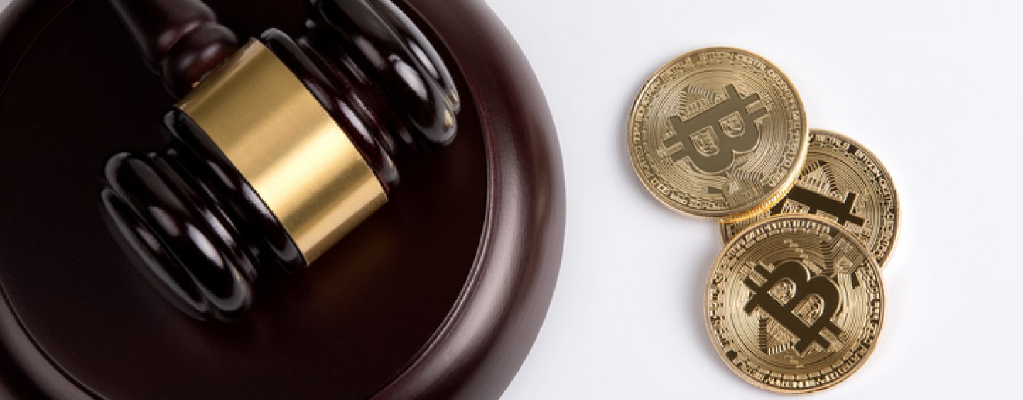 Picture of a gavel and sound block with three bitcoins right next to it