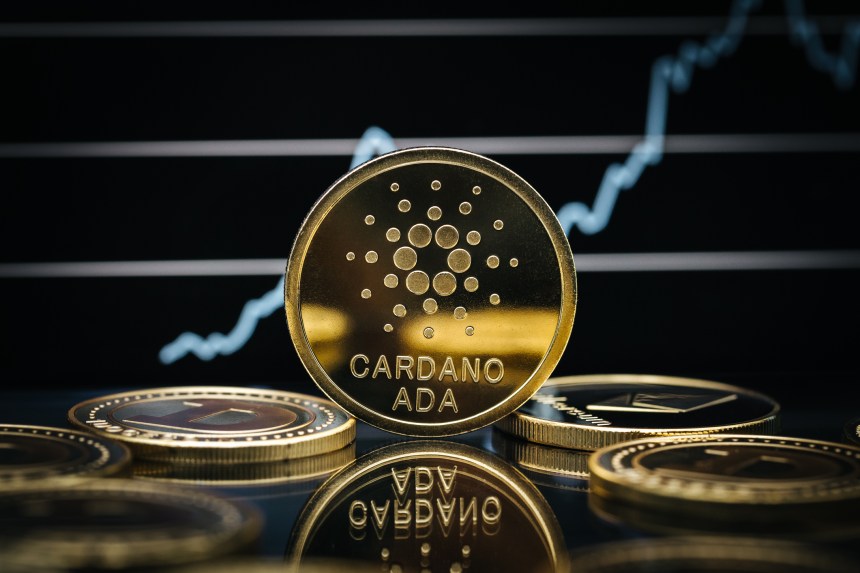 Cardano Ada cryptocurrency coin close-up, in front of a price chart